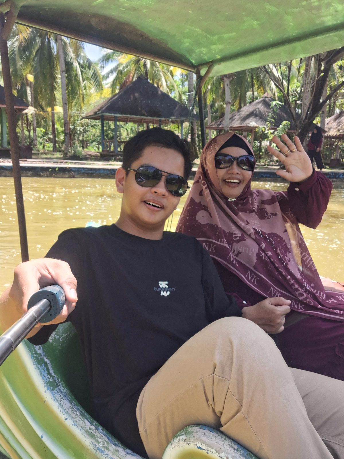 Ummi melambai dari perahu bersama anaknya